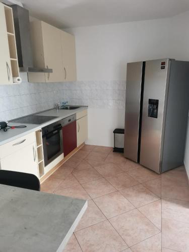 a kitchen with a stainless steel refrigerator and a tile floor at Bob's Zimmer in Bielefeld