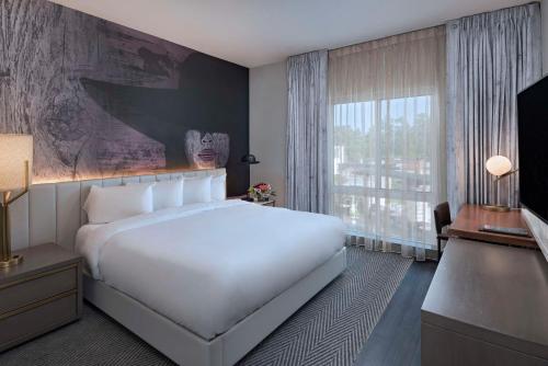 a bedroom with a white bed and a large window at Hyatt Centric The Woodlands in The Woodlands