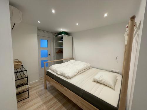 1 dormitorio pequeño con 1 cama con sábanas blancas en Precioso apartamento céntrico con piscina, en S'Agaró