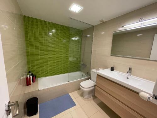 y baño con bañera, aseo y lavamanos. en Precioso apartamento céntrico con piscina, en S'Agaró