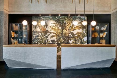 a restaurant with a counter with plants on the wall at Hyatt Centric MG Road Bangalore in Bengaluru