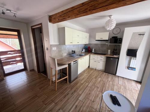 a kitchen with white cabinets and a wooden floor at Apartamenty Kadłubek in Wisła