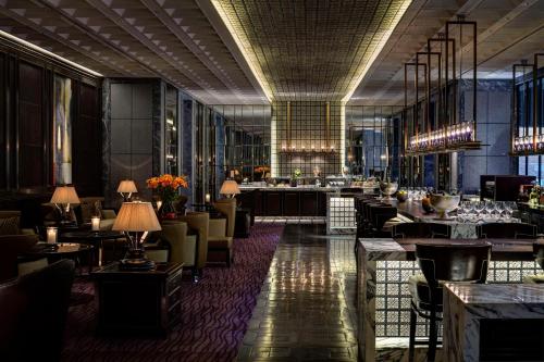 a restaurant with tables and chairs and a bar at Park Hyatt Hotel and Residences, Hyderabad in Hyderabad