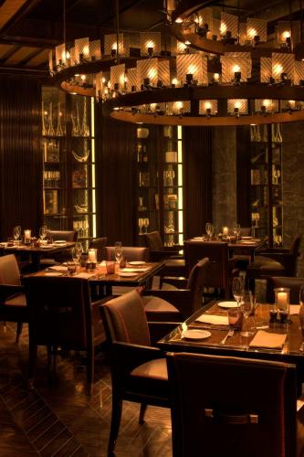 a restaurant with tables and chairs and a chandelier at Park Hyatt Hotel and Residences, Hyderabad in Hyderabad