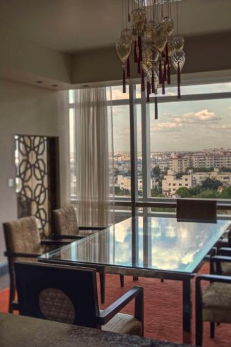 a dining room with a glass table and a large window at Park Hyatt Hotel and Residences, Hyderabad in Hyderabad
