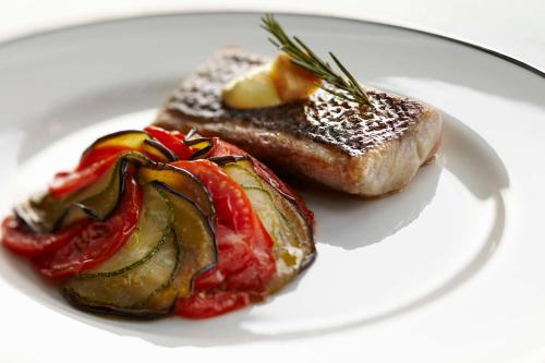 a plate of food with a piece of meat and fruit at Park Hyatt Hotel and Residences, Hyderabad in Hyderabad