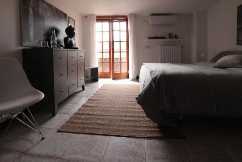 a bedroom with a bed and a dresser and a window at Vicolo Zenone 8 Casa Esclusiva tra Natura e Arte in Garzano