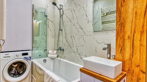 La salle de bains est pourvue d'un lave-linge et d'un lavabo. dans l'établissement Apartament Kwisa - 5D Apartamenty, à Świeradów-Zdrój