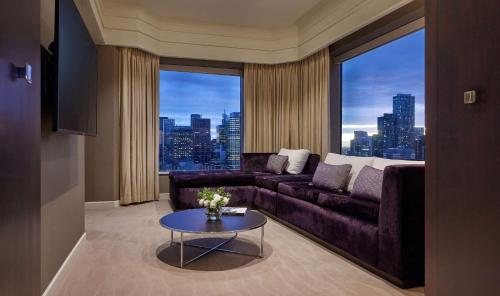 a living room with a purple couch and a large window at Grand Hyatt Melbourne in Melbourne