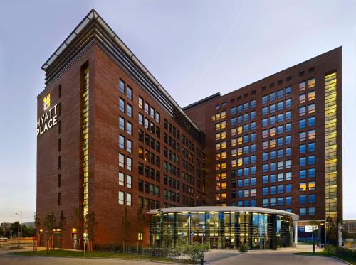 een groot bakstenen gebouw met een bord erop bij Hyatt Place Amsterdam Airport in Hoofddorp