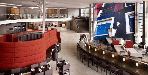 a lobby with chairs and a bar in a building at Hyatt Place Amsterdam Airport in Hoofddorp