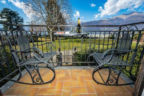 two chairs sitting in front of a iron fence at VILLA LAGO foreground - Pet friendly stay- garden-parking-Lake view- Bike friendly holiday house in Colico