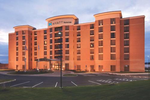 a large red brick building with a sign on it at Hyatt House Hartford North/Windsor in Windsor