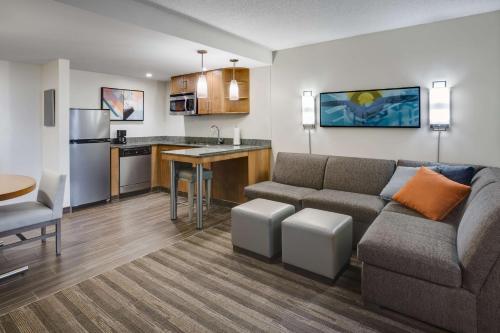 a living room with a couch and a kitchen at Hyatt House Hartford North/Windsor in Windsor