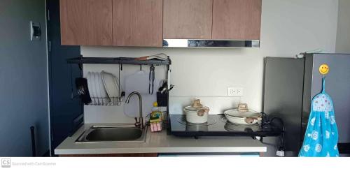 een kleine keuken met een wastafel en een magnetron bij Adam&Eva Condo Staycation in Lapu Lapu City