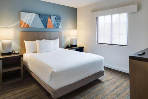 a bedroom with a white bed and a window at Hyatt House Boston Waltham in Waltham
