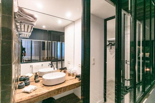 łazienka z 2 umywalkami i dużym lustrem w obiekcie Gabrielle Jeanne w mieście Maillane