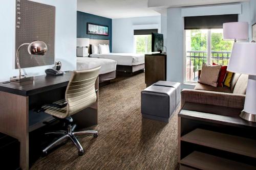 a hotel room with a desk and a bedroom at Hyatt House Branchburg - Bridgewater in Branchburg Park