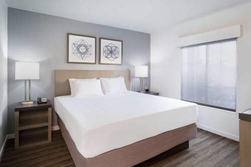 a bedroom with a large white bed and a window at Hyatt House White Plains in White Plains