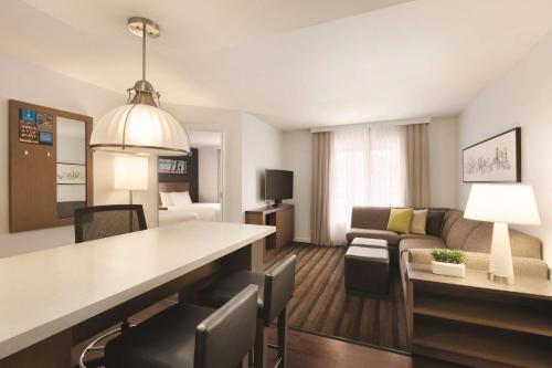 a room with a living room and a hotel room at Hyatt House Miami Airport in Miami