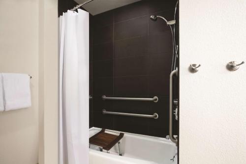 a bathroom with a shower with a tub and a toilet at Hyatt House Pleasant Hill in Pleasant Hill