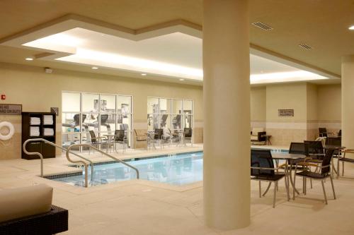 a pool in a room with chairs and a table at Hyatt House Philadelphia-King of Prussia in King of Prussia