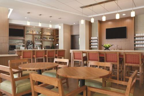 a restaurant with tables and chairs and a bar at Hyatt Place at Anaheim Resort / Convention Center in Anaheim