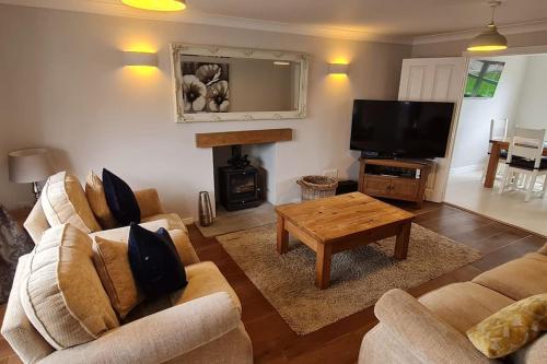a living room with two couches and a television at Spacious four bed detached home in Nottingham in Nottingham
