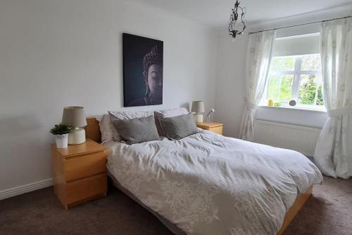 a bedroom with a white bed and a window at Four bed detached home in Nottingham in Nottingham