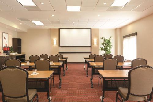 a conference room with tables and chairs and a screen at Hyatt Place at Anaheim Resort / Convention Center in Anaheim