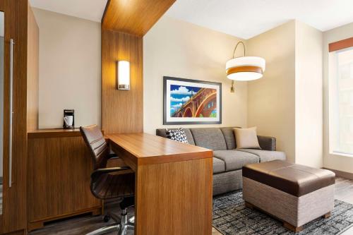 a living room with a couch and a desk at Hyatt Place Columbia/Downtown/The Vista in Columbia