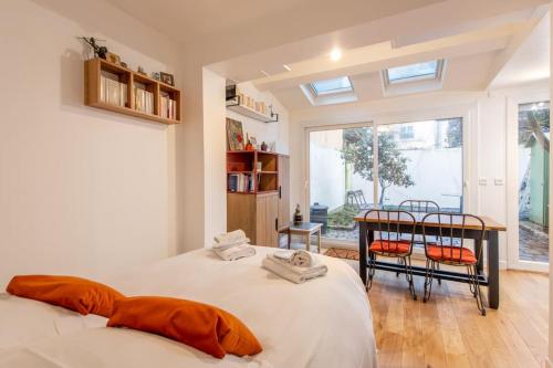 1 Schlafzimmer mit 2 Betten, einem Tisch und Stühlen in der Unterkunft Malakoff - Cosy appartement tout équipé aux portes de Paris in Malakoff