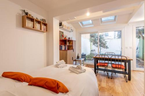 une chambre avec deux lits et une table et des chaises dans l'établissement Malakoff - Cosy appartement tout équipé aux portes de Paris, à Malakoff