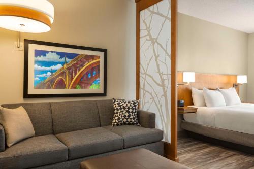a hotel room with a couch and a bed at Hyatt Place Columbia/Downtown/The Vista in Columbia