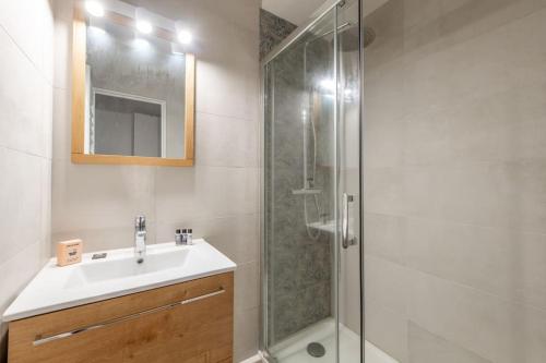 ein Bad mit einem Waschbecken und einer Dusche in der Unterkunft Malakoff - Cosy appartement tout équipé aux portes de Paris in Malakoff