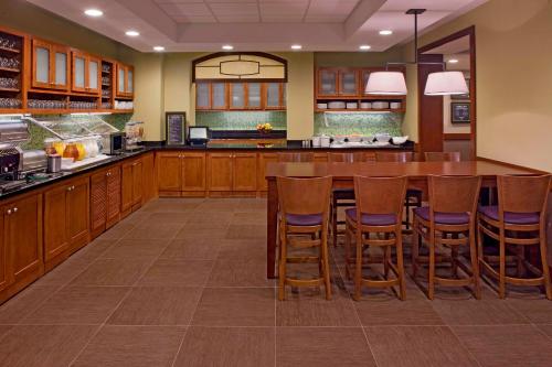 a large kitchen with a large wooden table and chairs at Hyatt Place North Charleston in Charleston