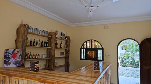 a tasting room with a counter with bottles of wine at Hotel Eyram in Palimé