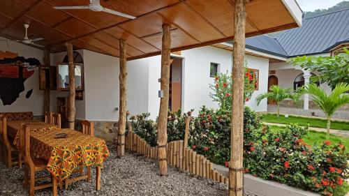 eine Terrasse mit einem Tisch und Stühlen unter einer Pergola in der Unterkunft Hotel Eyram in Palimé