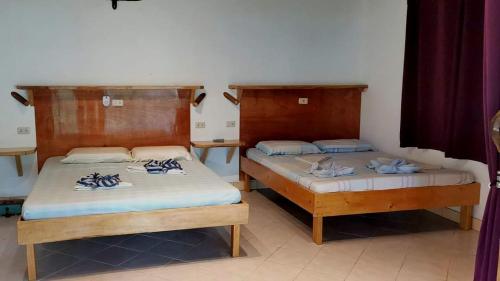 two beds sitting next to each other in a room at Sulu Sunset Beach Resort in Nauhang