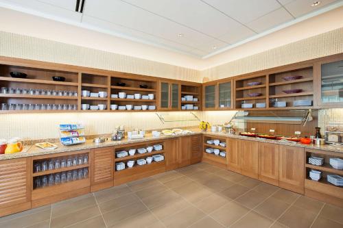 a large kitchen with wooden cabinets and shelves at Hyatt Place Champaign/Urbana in Champaign