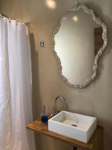 a bathroom with a sink and a mirror on the wall at Studios on the beach in Galaxidi