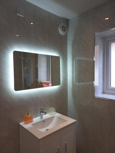 a bathroom with a sink and a mirror at Sea Breeze Studio @ The Coach House in Saint Annes on the Sea