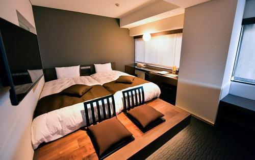 a bedroom with a large bed and a window at Tsukino HOTEL in Sakata