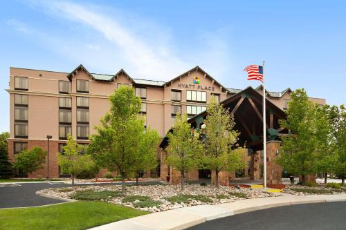 a building with an american flag in front of it at Hyatt Place Denver-South/Park Meadows in Lone Tree