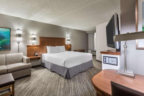 a large hotel room with a bed and a couch at Hyatt Place Atlanta Duluth Johns Creek in Johns Creek