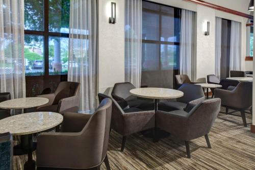 a waiting room with tables and chairs and windows at Hyatt Place Boise/Towne Square in Boise