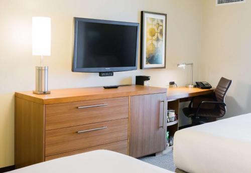 a hotel room with a desk and a television on a dresser at Hyatt Place Daytona Beach-Oceanfront in Daytona Beach