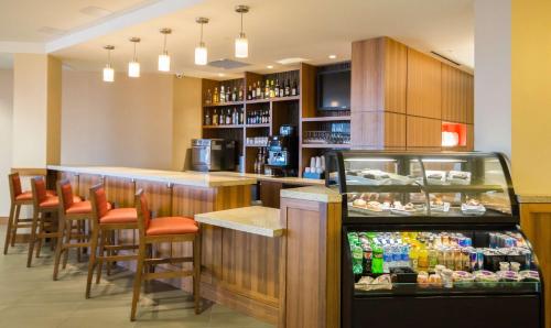 a restaurant with a bar with orange chairs and drinks at Hyatt Place Daytona Beach-Oceanfront in Daytona Beach