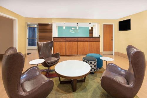 a waiting room with chairs and a table and a screen at Baymont by Wyndham Savannah Midtown in Savannah