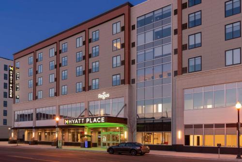 a building with a car parked in front of it at Hyatt Place Detroit/Royal Oak in Royal Oak